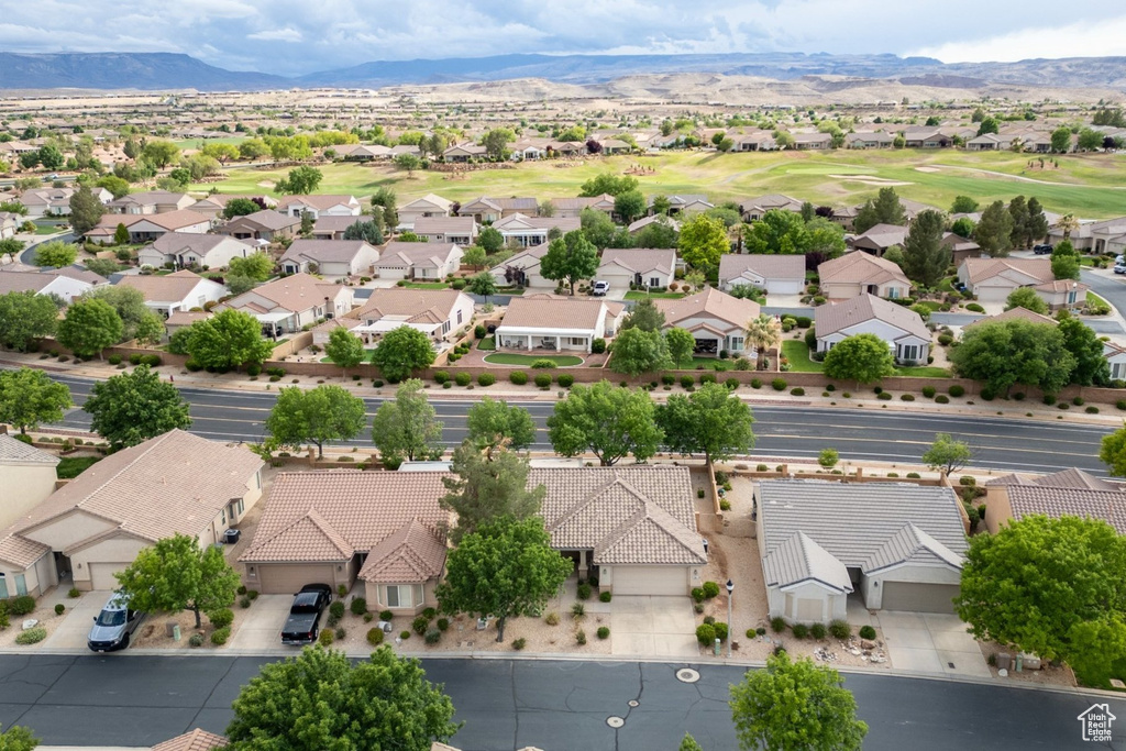Aerial perspective of suburban area featuring a mountain backdrop and a golf course