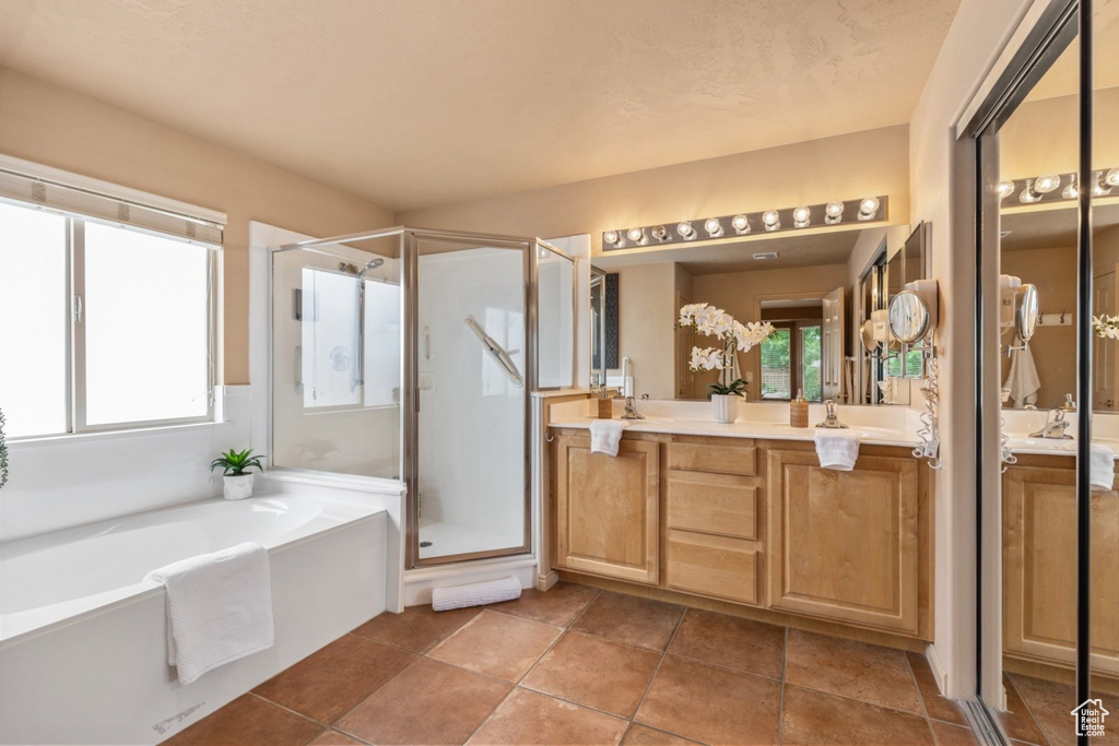 Full bath featuring a shower stall, vanity, and a garden tub
