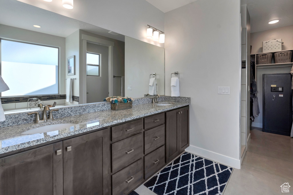 Full bath featuring baseboards and double vanity