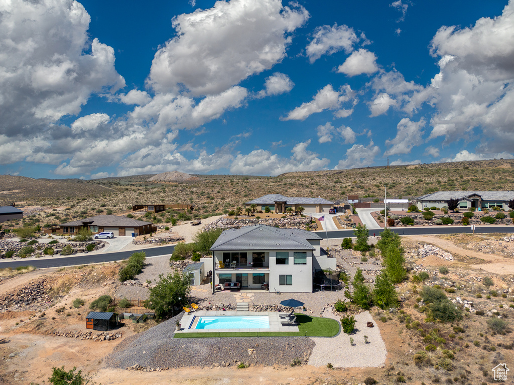 Aerial view of property and surrounding area featuring a mountain backdrop and a pool area