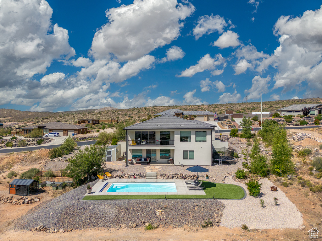 Swimming pool featuring a patio, fence, and a mountain view