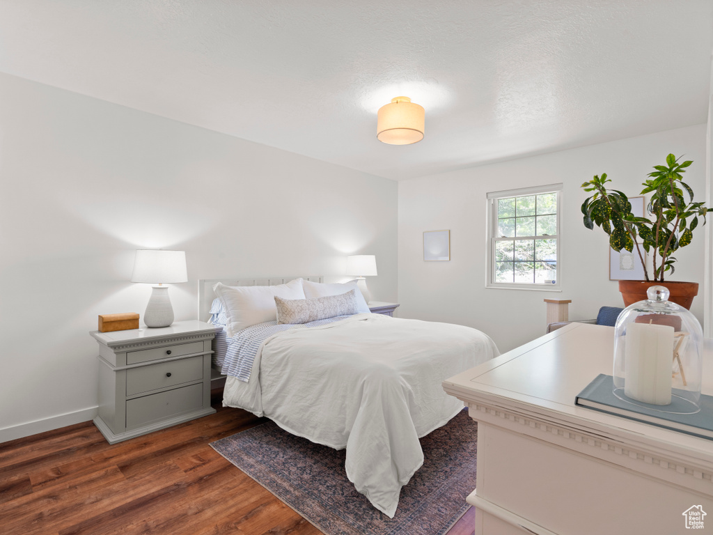 Bedroom featuring dark wood-style flooring and baseboards