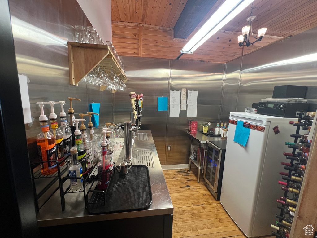 Kitchen with wine cooler, refrigerator, wooden ceiling, and light wood-style flooring