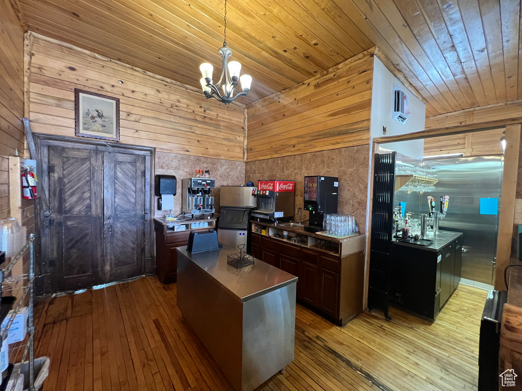 Office area with wooden ceiling, an inviting chandelier, wood walls, and light wood-type flooring