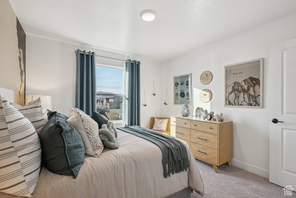 Bedroom with light carpet and baseboards