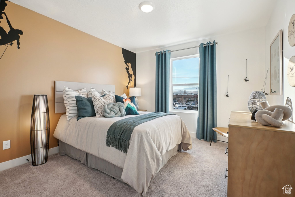 Bedroom featuring light carpet and baseboards