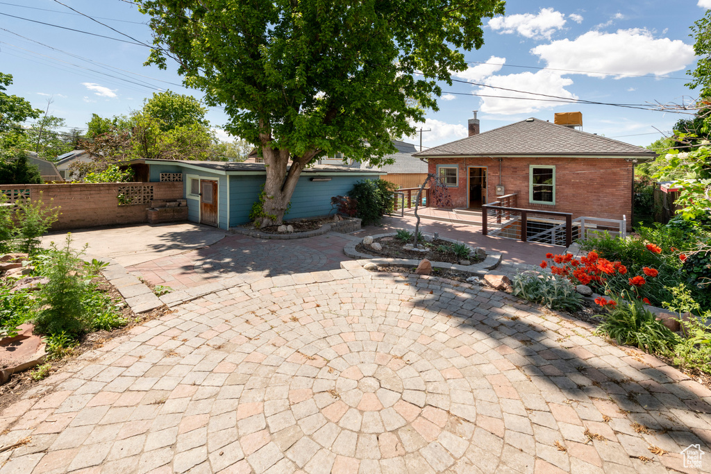 View of front facade with fence, brick siding, a patio area, and a chimney