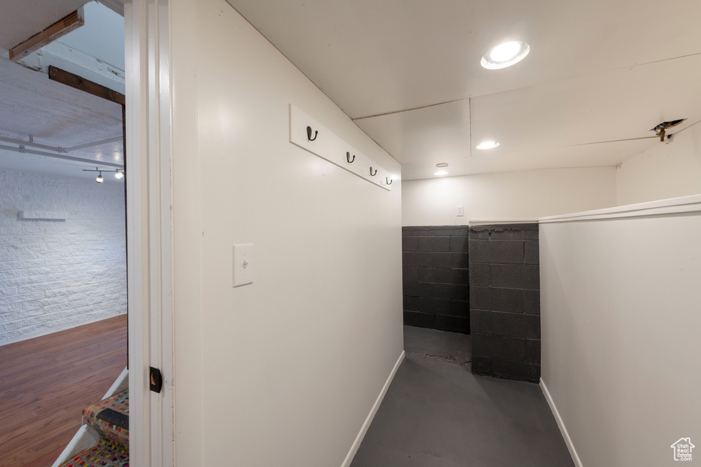Hall featuring baseboards and concrete floors