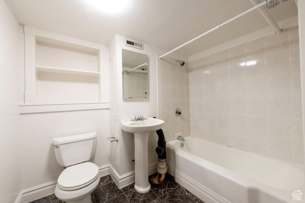 Full bath featuring baseboards, tub / shower combination, toilet, and marble finish floors