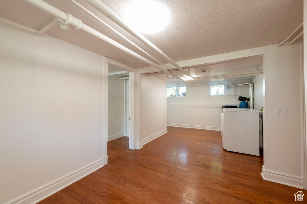 Basement featuring wood finished floors, a textured ceiling, and baseboards