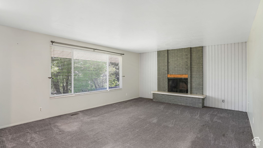 Unfurnished living room with carpet flooring and a fireplace