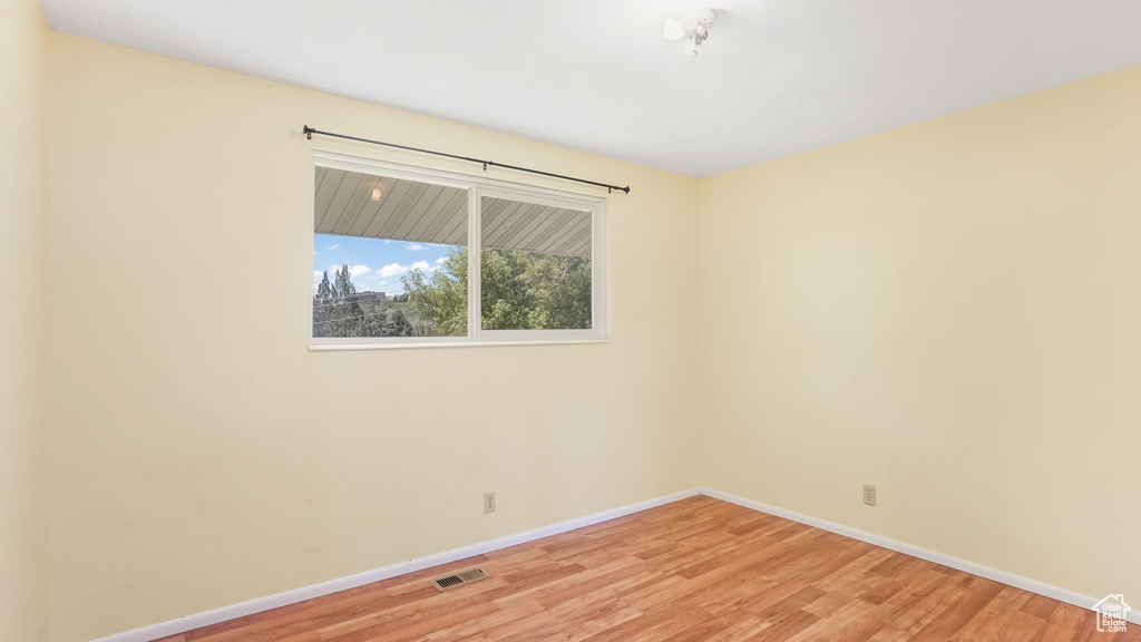 Spare room featuring light wood-style floors and baseboards