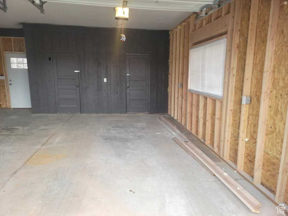 Garage featuring wood walls and a garage door opener