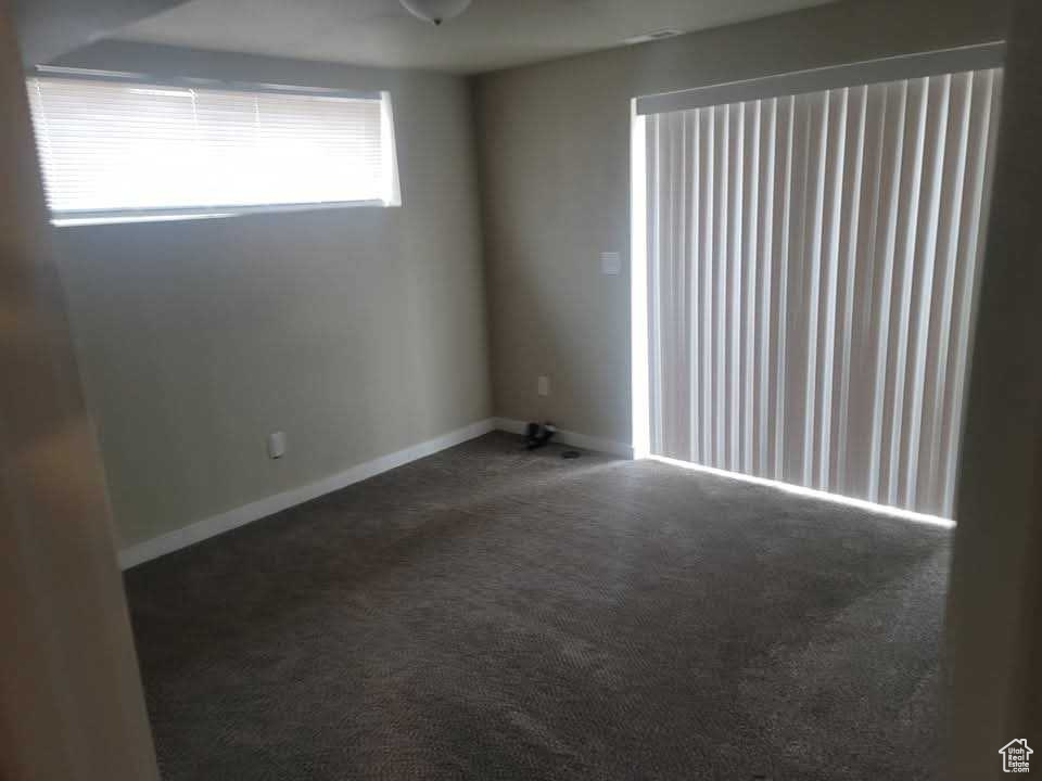 Carpeted spare room featuring baseboards