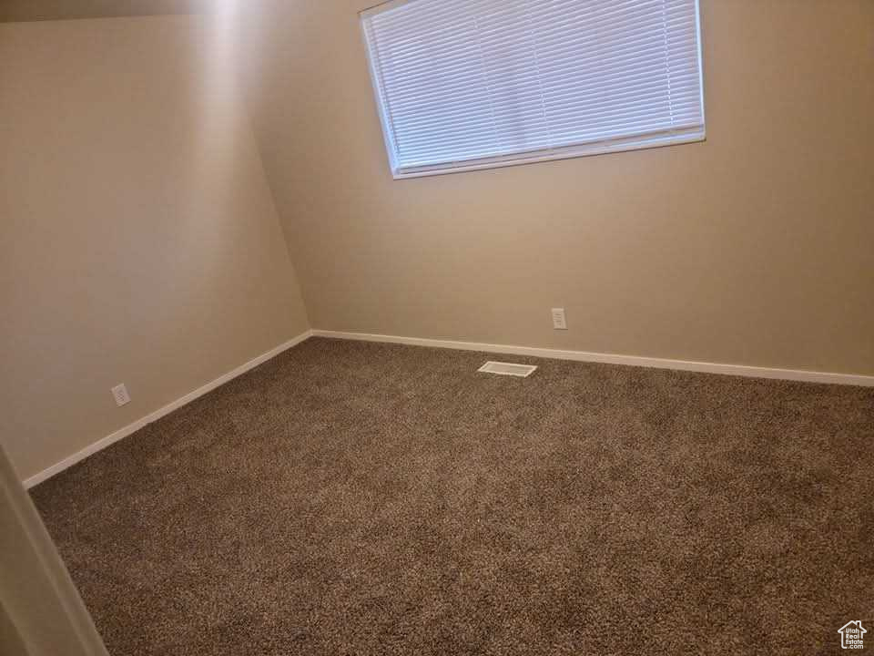 Empty room with carpet floors and baseboards