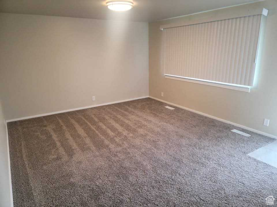 Carpeted empty room featuring baseboards