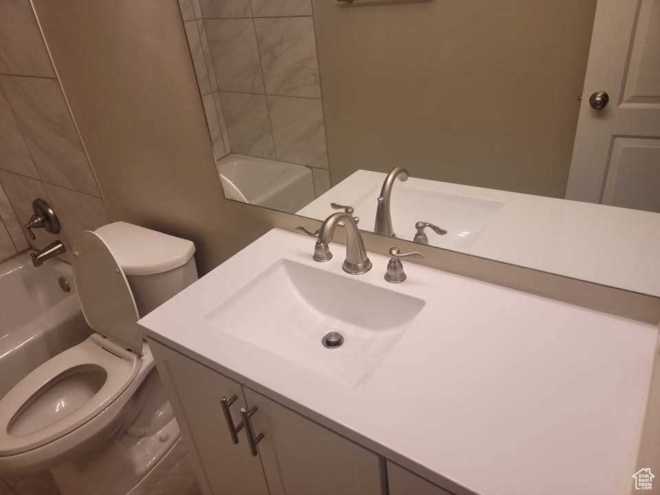 Full bath with toilet, vanity, and shower / bathtub combination