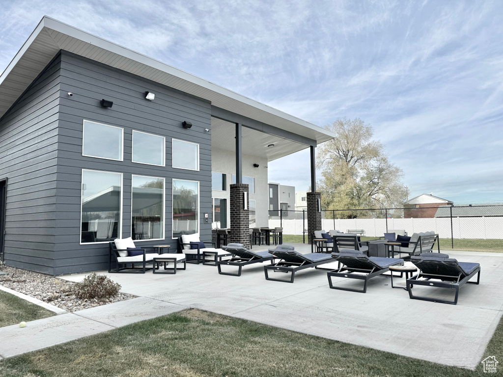 Rear view of house featuring fence, a patio area, and an outdoor hangout area