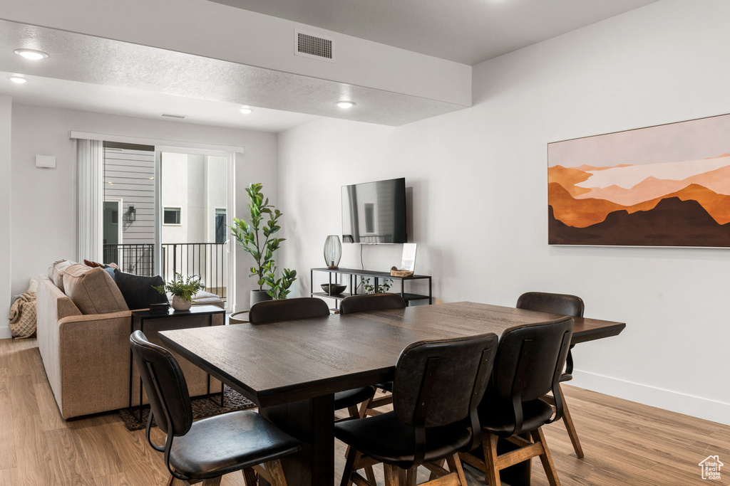 Dining area featuring light wood-style flooring, baseboards, and recessed lighting