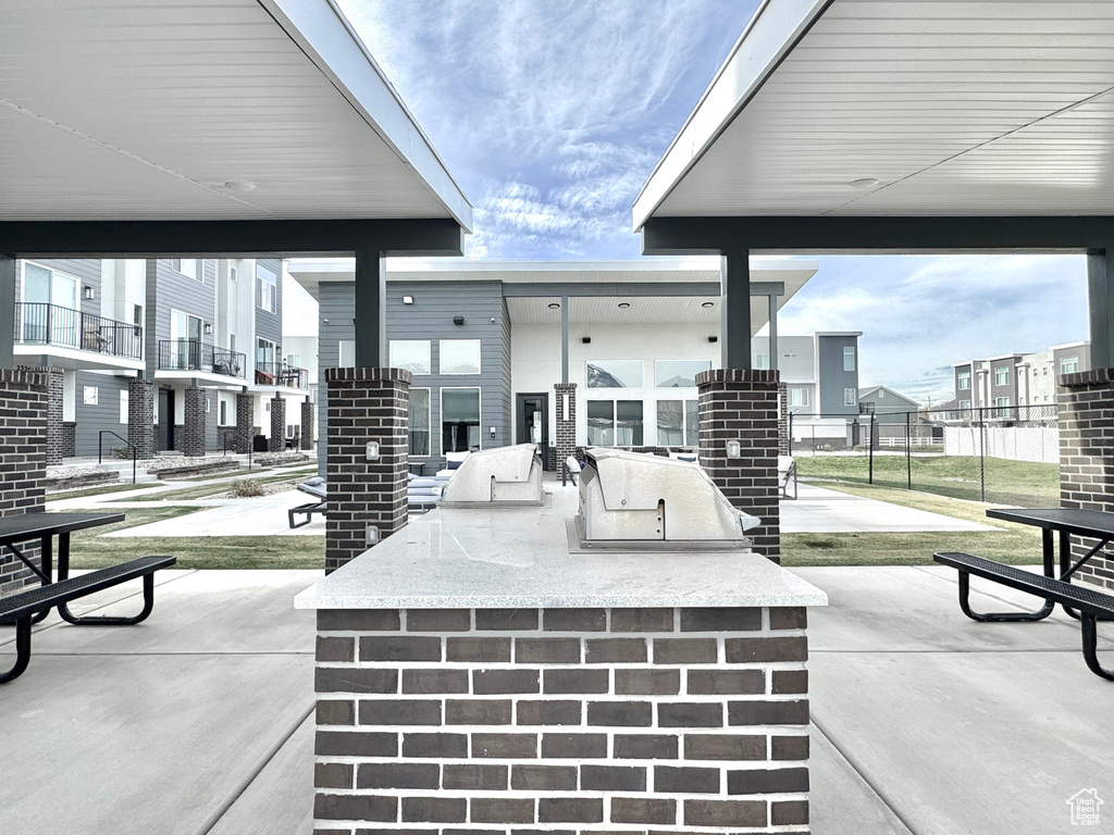 View of patio / terrace with exterior kitchen, fence, and a residential view