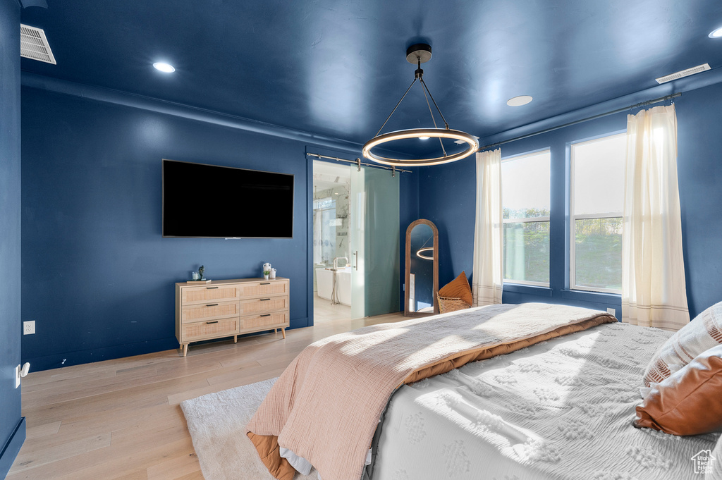 Bedroom with wood finished floors, ensuite bathroom, and recessed lighting