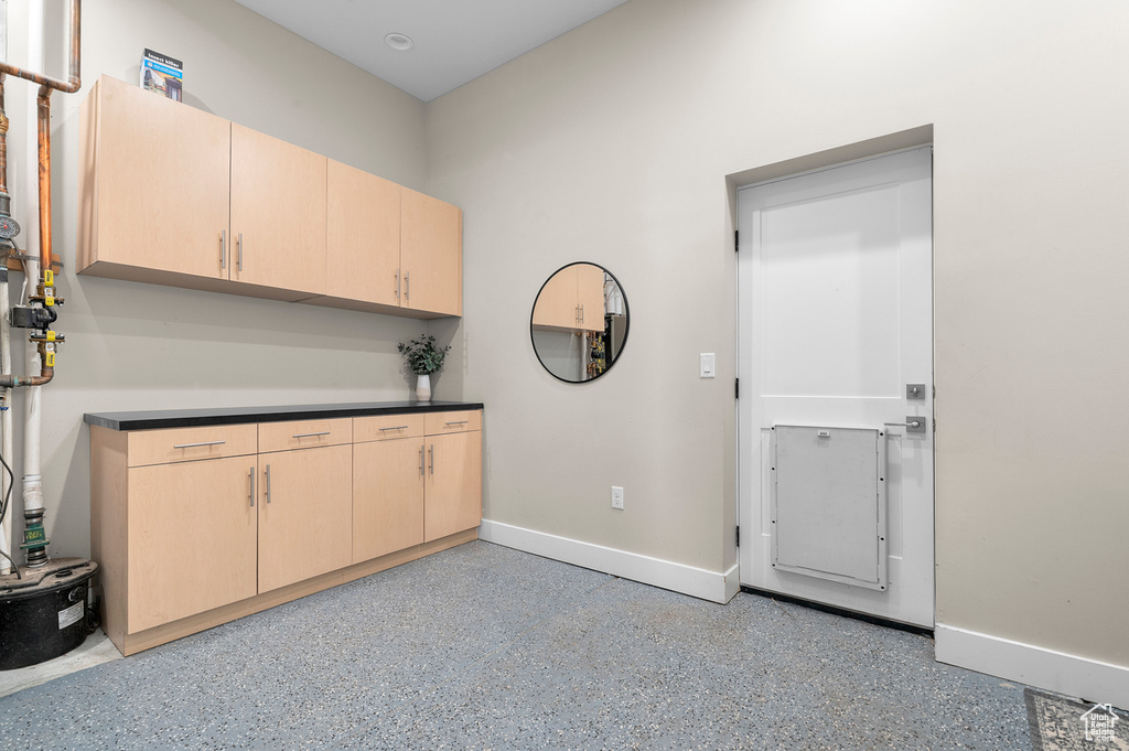 Kitchen with light brown cabinets, baseboards, and dark countertops