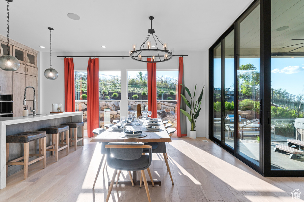 Dining space with a chandelier, light wood-type flooring, and recessed lighting