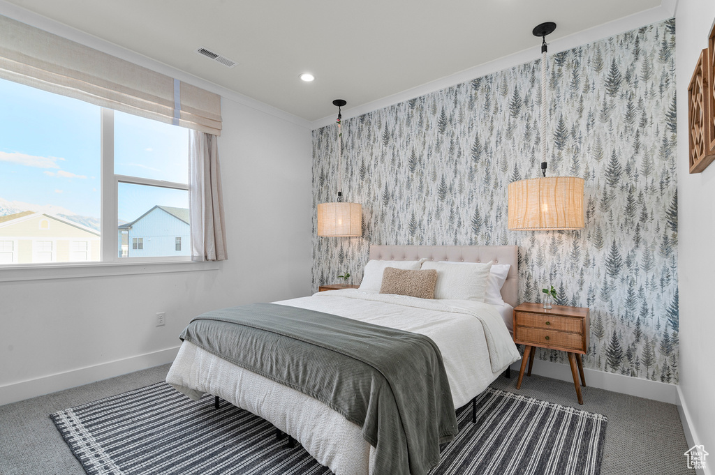 Carpeted bedroom featuring wallpapered walls, baseboards, crown molding, and recessed lighting