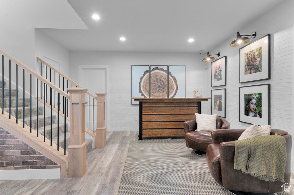 Living area with wood finished floors, stairs, and recessed lighting
