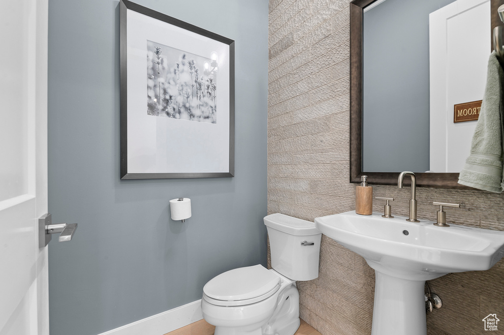 Half bath featuring toilet and a sink