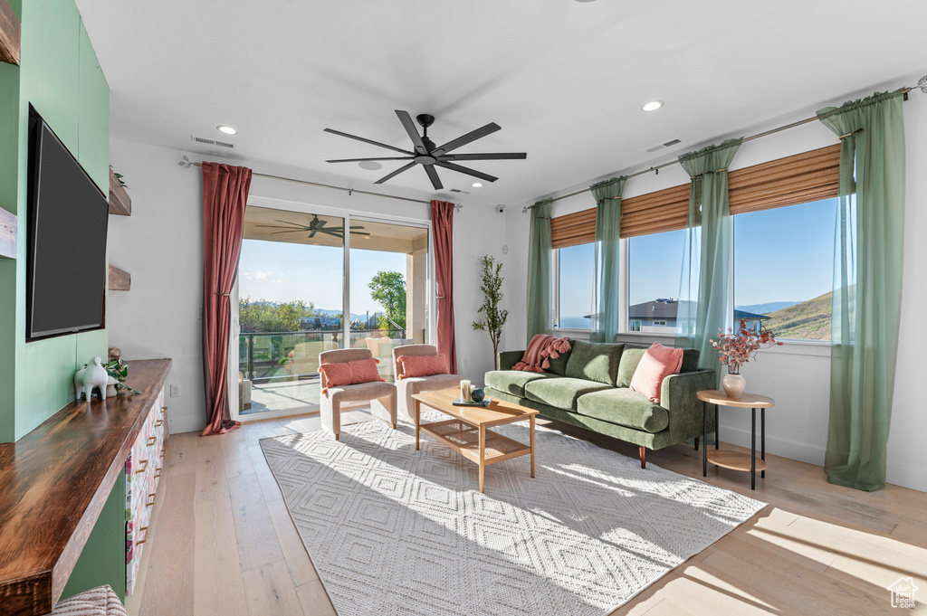 Living room with plenty of natural light, a ceiling fan, light wood-style flooring, and recessed lighting