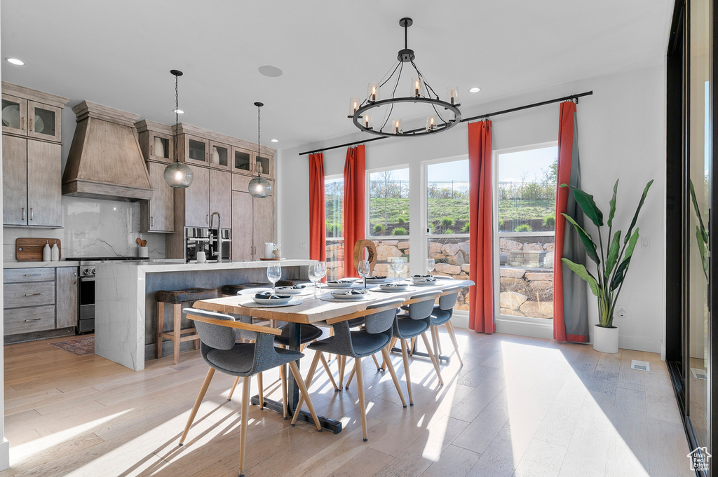 Dining room with a chandelier, light wood-style flooring, and recessed lighting