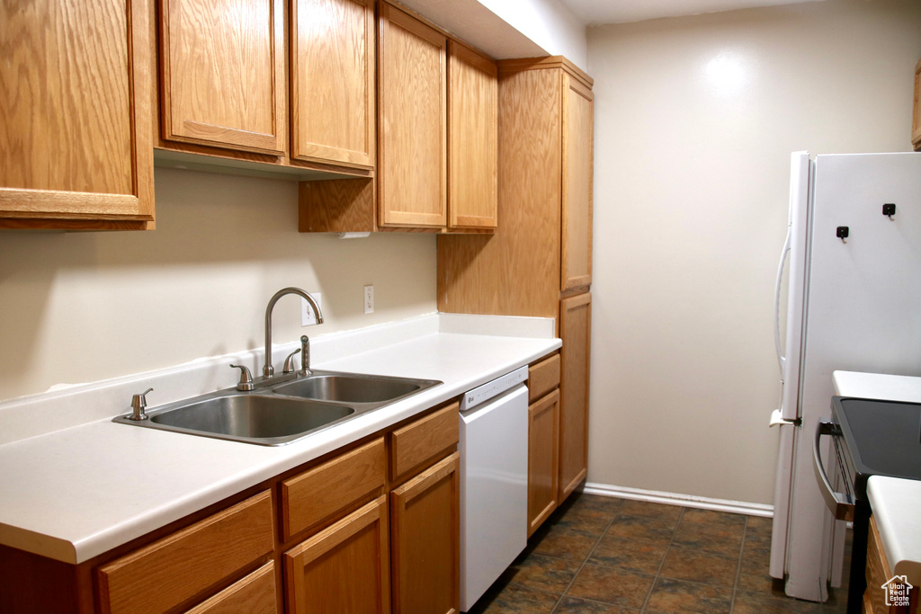 Kitchen with white dishwasher, a sink, range with electric cooktop, and light countertops