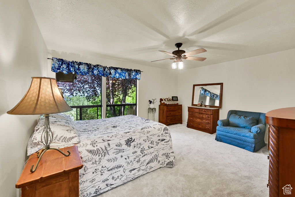 Carpeted bedroom with a ceiling fan
