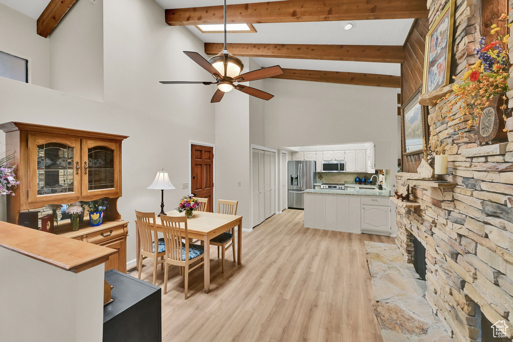 Kitchen featuring appliances with stainless steel finishes, light countertops, high vaulted ceiling, ceiling fan, and a peninsula