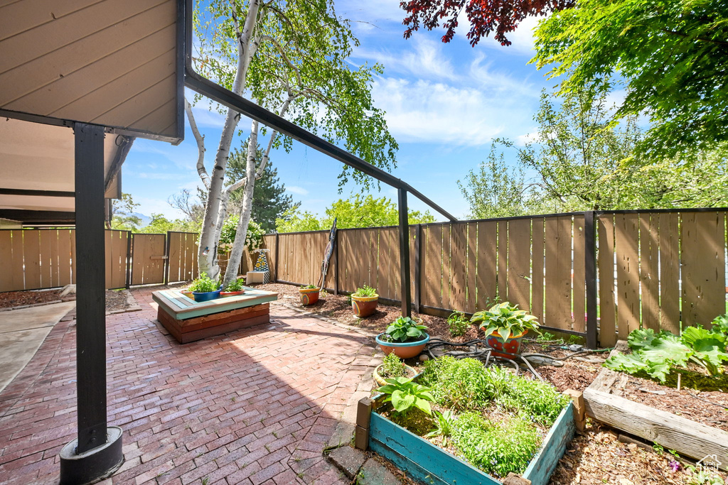 View of patio featuring a vegetable garden and a fenced backyard