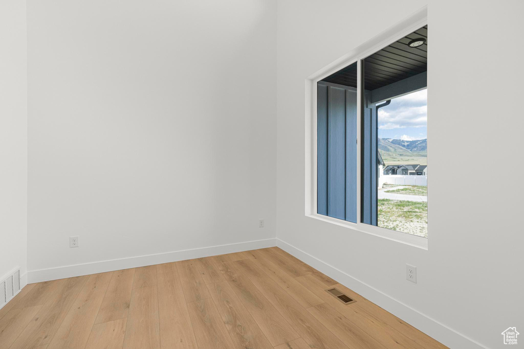 Spare room with light wood-style flooring, baseboards, and a mountain view