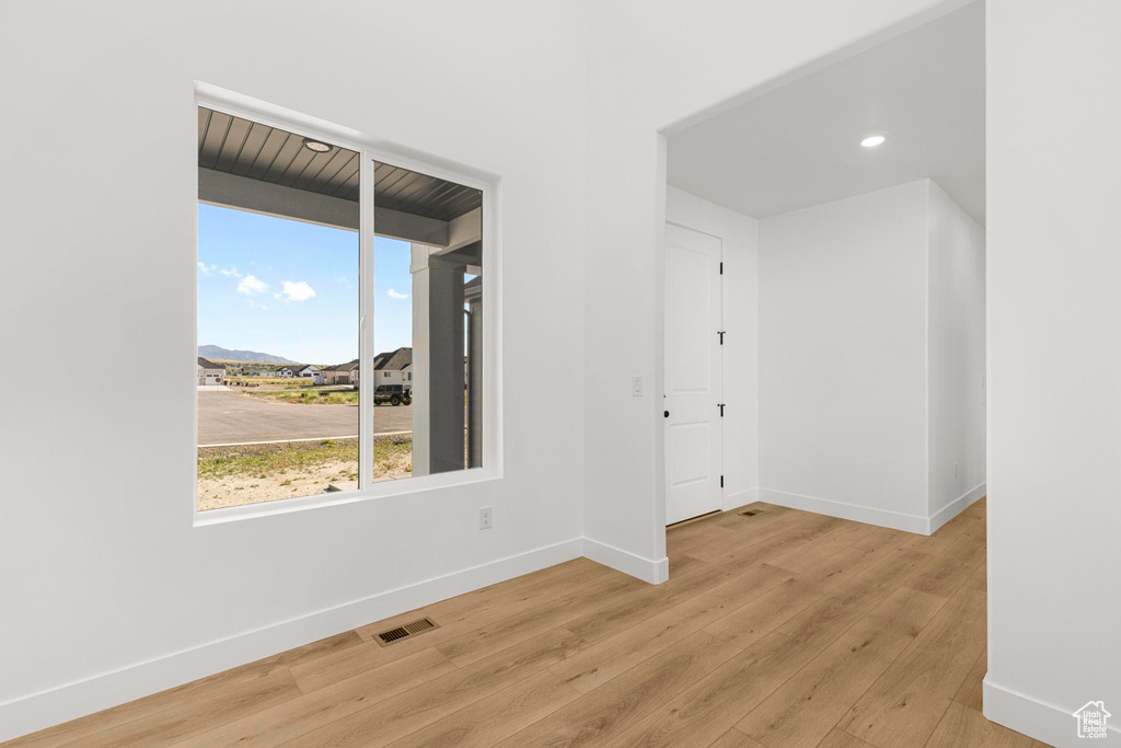 Spare room featuring light wood finished floors, baseboards, recessed lighting, and a mountain view
