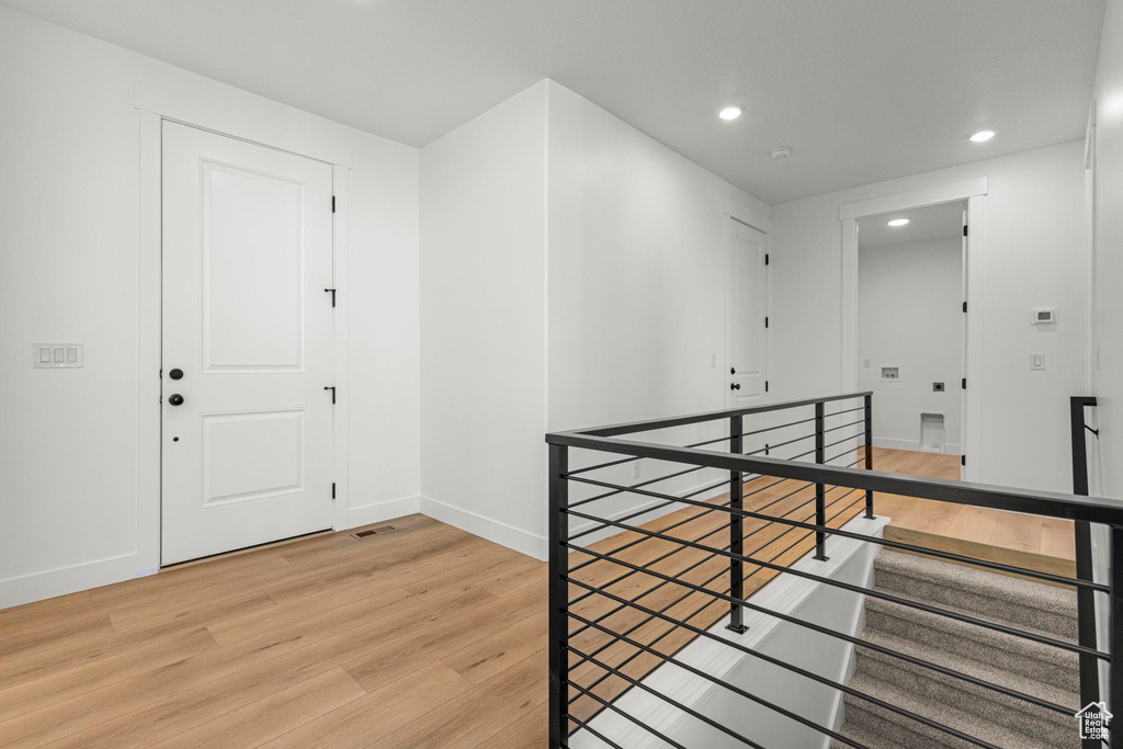 Corridor featuring an upstairs landing, light wood finished floors, recessed lighting, and baseboards