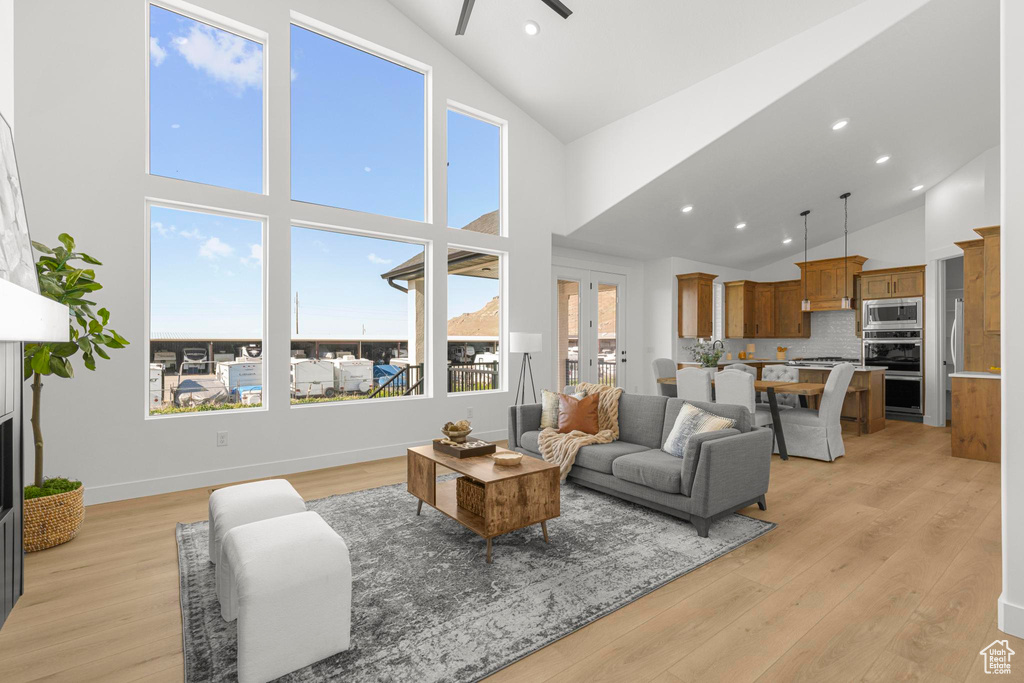 Living area featuring light wood-style floors, a ceiling fan, recessed lighting, and high vaulted ceiling