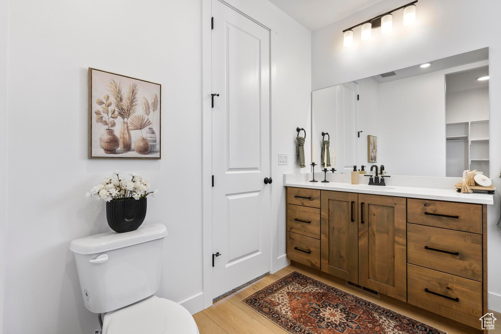 Bathroom with wood finished floors, toilet, and vanity