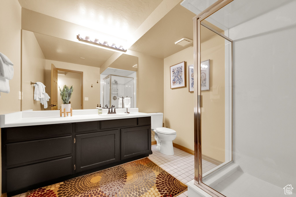Full bath featuring a shower stall, toilet, tile patterned floors, and vanity