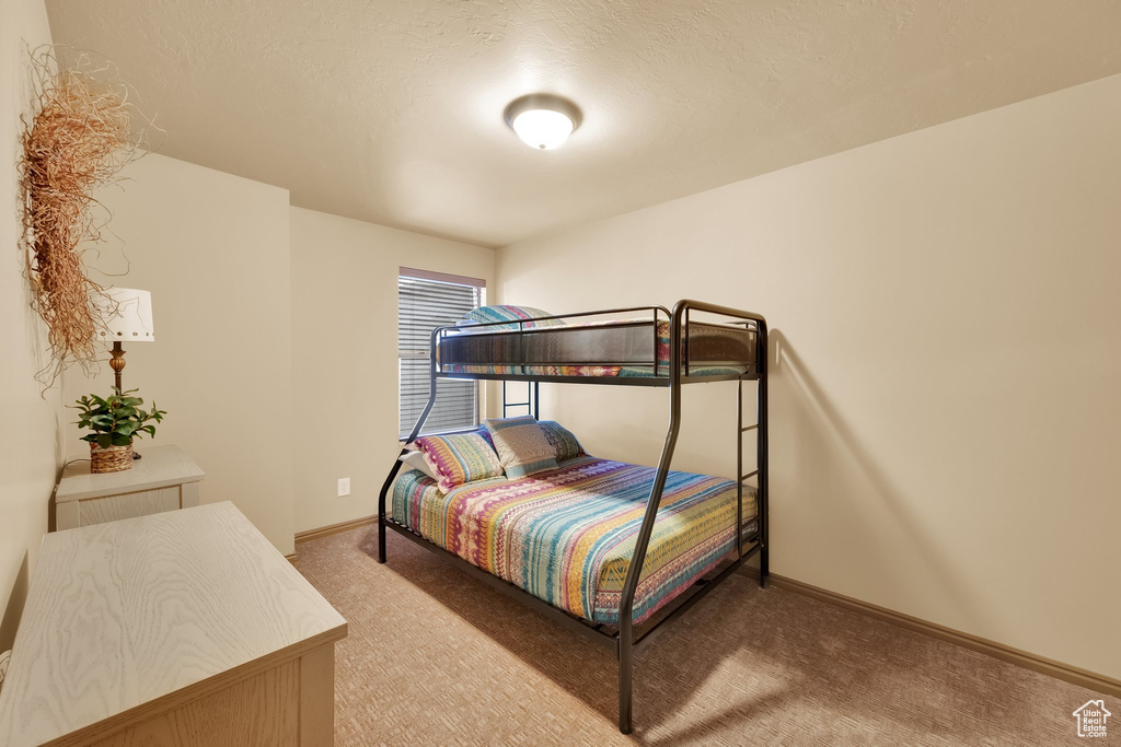 Bedroom with light carpet and baseboards