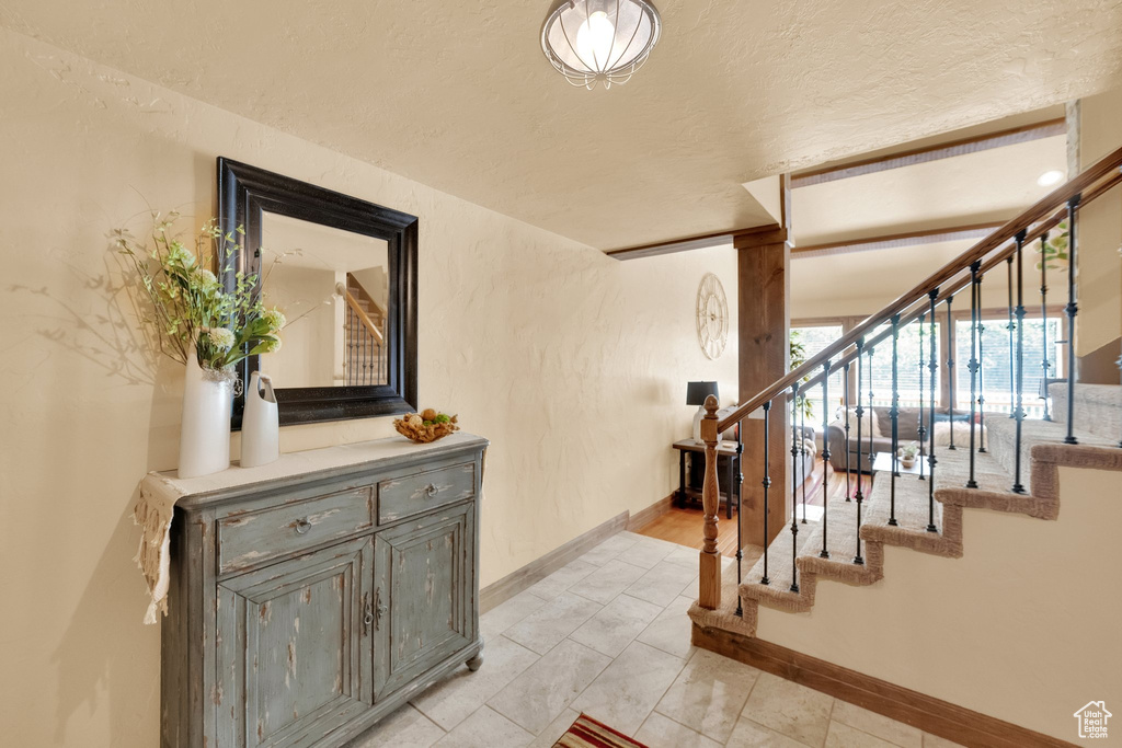 Stairway with baseboards and a textured ceiling