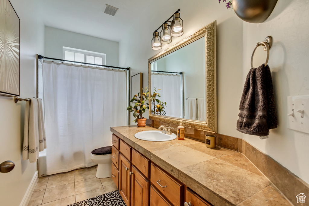 Bathroom with vanity, toilet, tile patterned flooring, and shower / bathtub combination with curtain