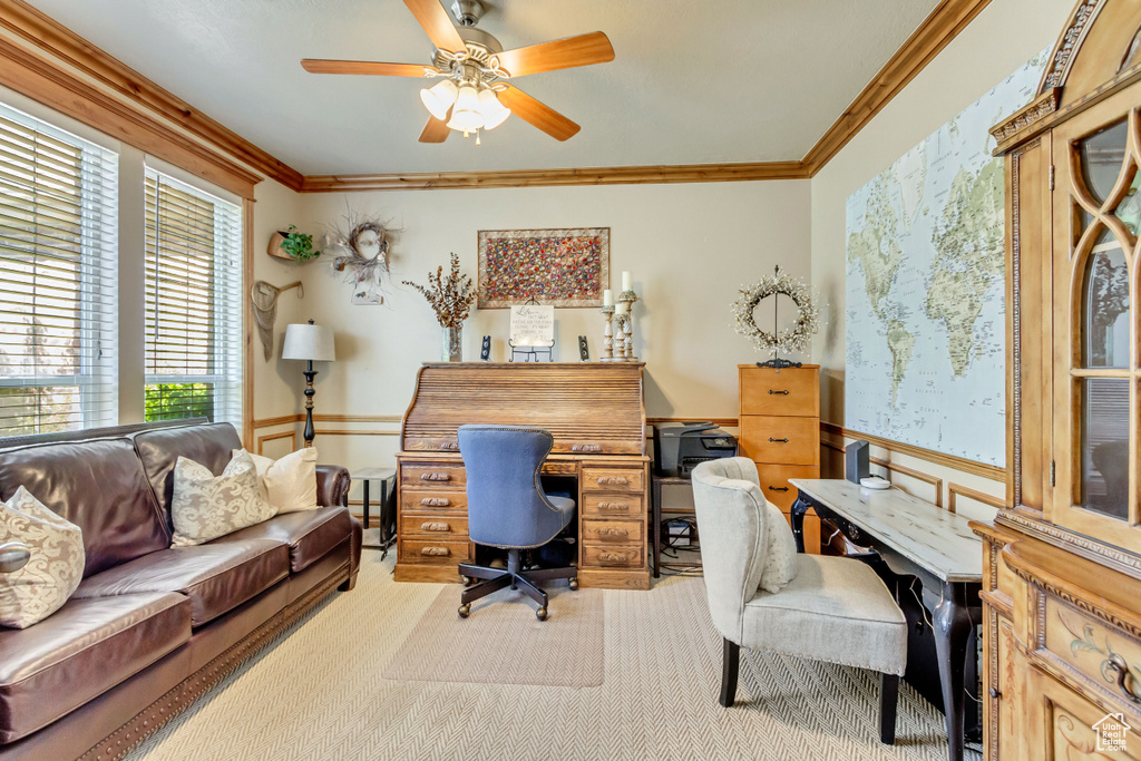 Office with light carpet, wainscoting, crown molding, and a ceiling fan