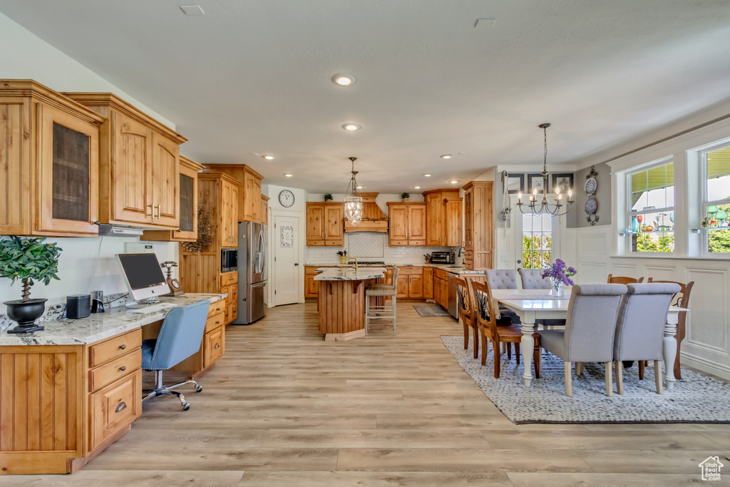 Dining room featuring a chandelier, light wood-style flooring, and recessed lighting