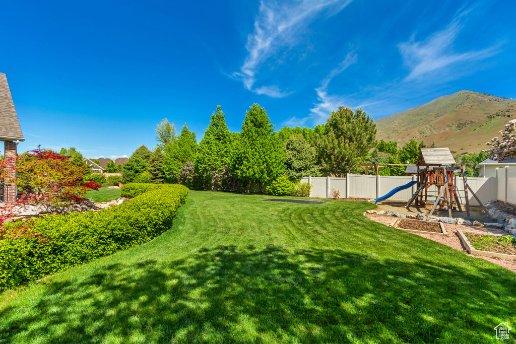 View of yard with a playground and a mountain view