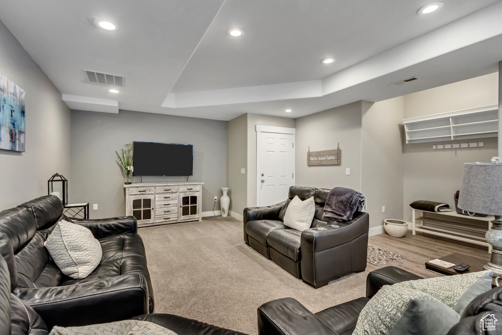 Living room featuring recessed lighting, baseboards, and a raised ceiling