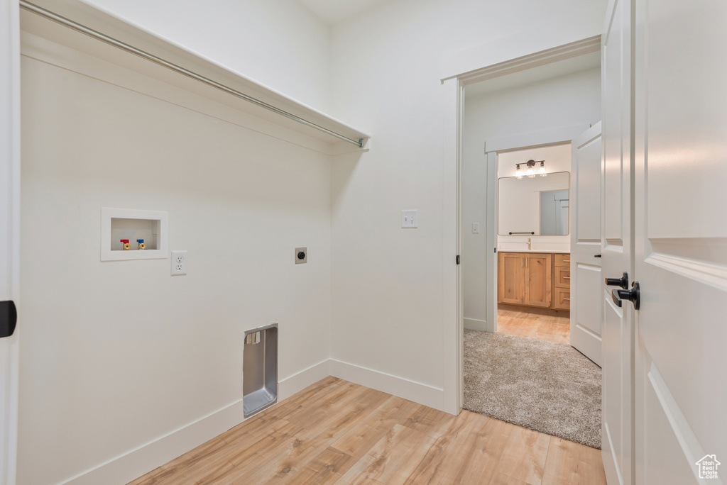 Washroom with washer hookup, light wood-style flooring, hookup for an electric dryer, and baseboards